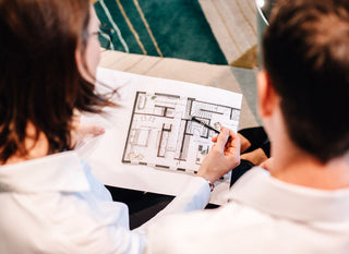 Zwei Personen bei der Einrichtungsberatung in Erlangen für das Gebiet Nürnberg und Fürth blicken auf einen Grundriss